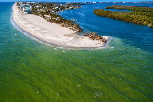 Aerial view of the north side of Milton Pass on Manasota Key after Hurricane Milton, showing the newly formed shoreline between the Gulf and Lemon Bay.