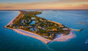 Aerial sunset view of Boca Grande and Gasparilla Island with white sand beaches, turquoise Gulf waters, and coastal homes in Southwest Florida