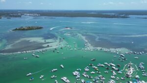 Aerial view of Boca Grande sandbar filled with boats in shallow turquoise water near Gasparilla Sound in Southwest Florida