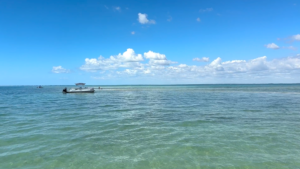 Boat floating in shallow turquoise waters near Bokeelia Sandbar in Pine Island Sound Florida
