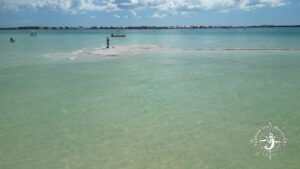 Drone view of shallow sandbar and clear turquoise water near Bokeelia Florida with small boats and visitors
