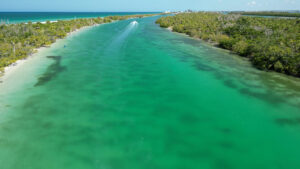 Aerial view of Coastal Ski Alley near South Gulf Cove Florida with emerald green water, mangroves, and a boat traveling toward the Gulf