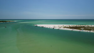 Aerial view of boats anchored along a white sandbar at Gasparilla Pass in Southwest Florida with turquoise Gulf waters