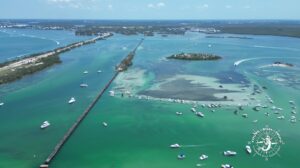 Aerial view of Placida trestle bridge and Boca Grande Sandbar in Gasparilla Sound with boats in shallow water during private tour with Florida Gulf Discovery