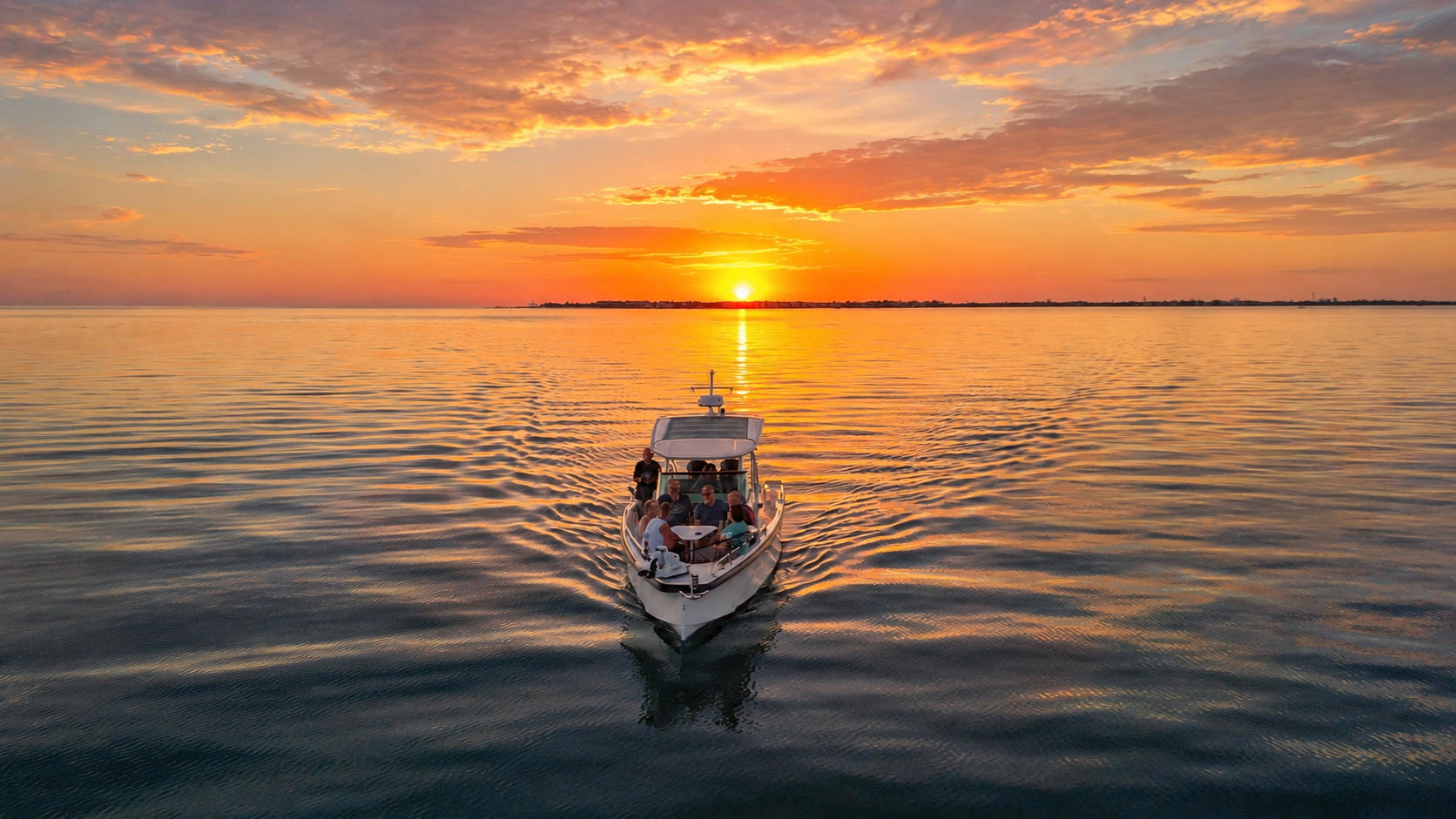 Aerial drone view of a boat cruising across calm waters at sunset in Boca Grande Pass, Florida.