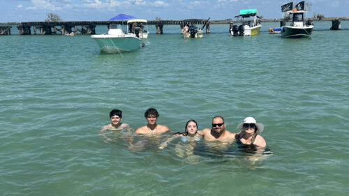 Family enjoying the shallow waters of Boca Grande Sandbar in Southwest Florida near the historic Placida Trestle