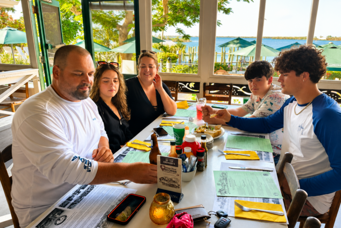Family Lunch at Cabbage Key Restaurant Family enjoying lunch at the waterfront restaurant on Cabbage Key during a private boat tour in Southwest Florida.