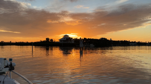 Sunset view of Cabbage Key from a boat with golden reflections across Pine Island Sound.