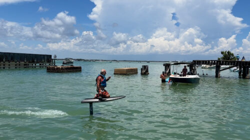 Captain Pavel riding an e-foil near the Historic Placida Trestle during a private water adventure in Southwest Florida.