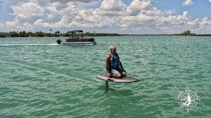 Captain Pavel riding an e-foil board across the turquoise waters of Gasparilla Sound near Boca Grande, Florida.
