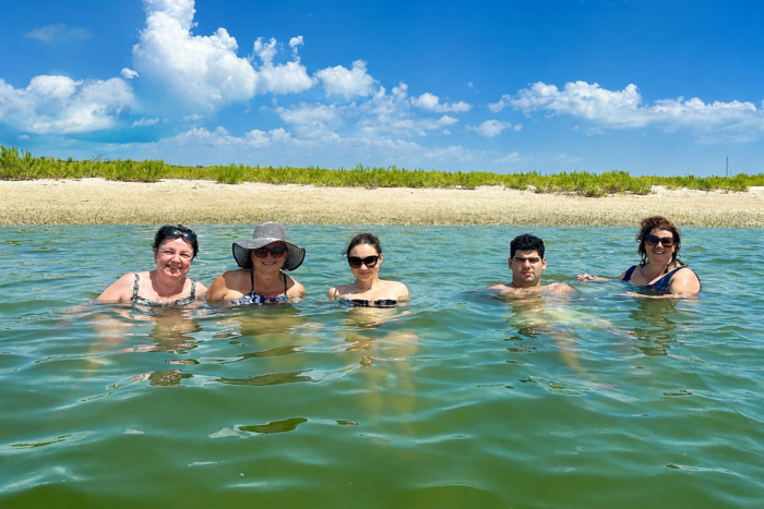 Guests swimming in the crystal-clear waters of Cayo Costa Lagoon during a private boat tour in Southwest Florida.