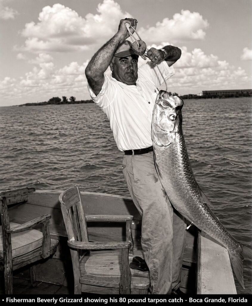 Commercial fisherman Beverly Grizzard displaying an 80-pound tarpon aboard a boat near Boca Grande, Florida.