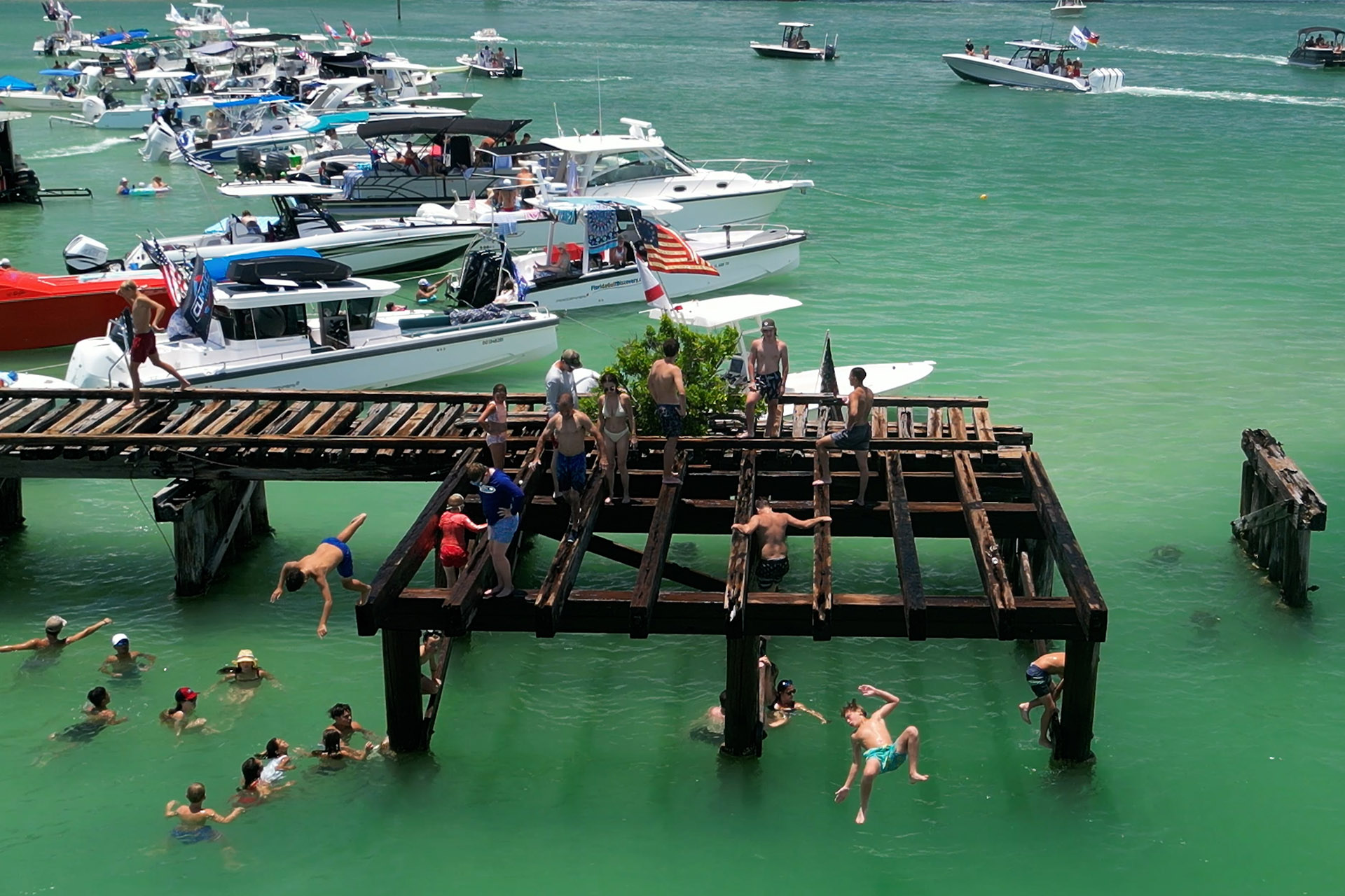 People jumping from the historic Boca Grande railroad trestle near Placida during Independence Day in Southwest Florida