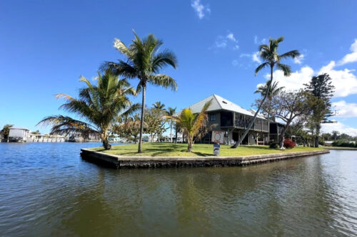 Luxury waterfront home with private seawall and palm trees in Bokeelia on Pine Island, Florida.