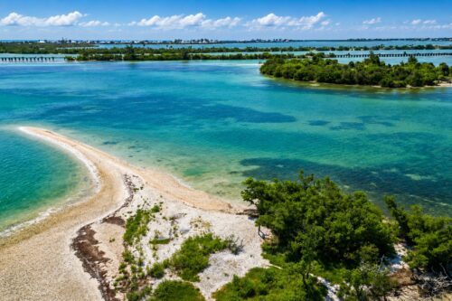 Aerial view of Gasparilla Sound showing Dog Island, the historic Placida Railroad Trestle, shallow estuarine waters, and the protected coastal landscape of Southwest Florida.
