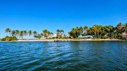 Luxury waterfront homes and palm-lined shoreline at Little Bokeelia Bay on Pine Island, Southwest Florida.