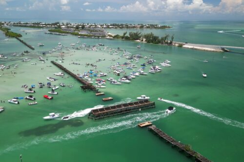 Drone view of Placida Trestle and Boca Grande Sandbar with hundreds of boats enjoying one of Southwest Florida's most popular boating destinations.