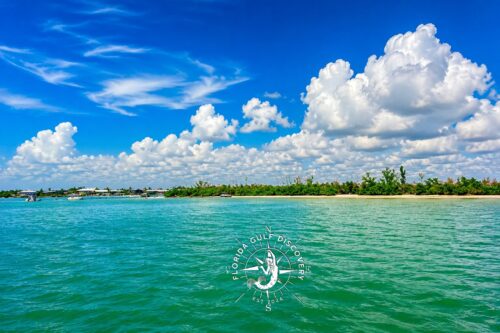Panoramic view of Bird Key Sandbar with emerald-green water, mangrove shoreline, and dramatic summer clouds in Southwest Florida.