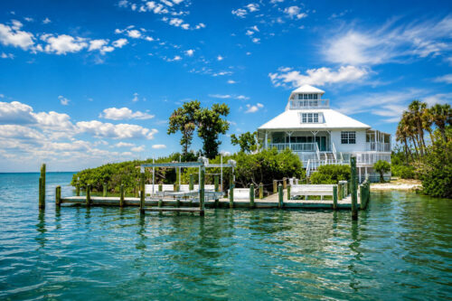 Waterfront home and private dock on Cabbage Key surrounded by tropical vegetation and Pine Island Sound in Southwest Florida.