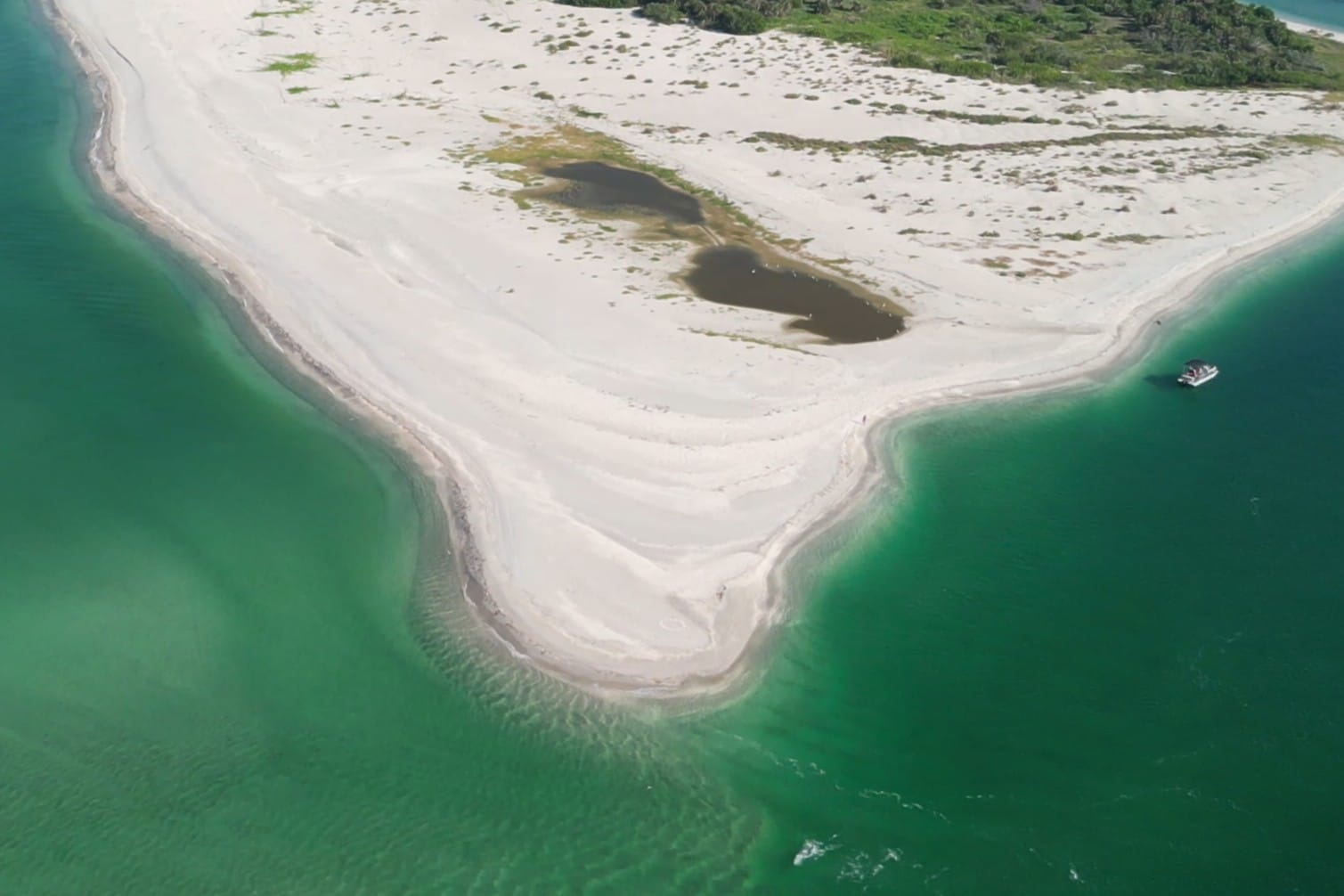 Aerial view of the sandy tongue extending from Stump Pass Beach State Park into the clear waters of Stump Pass, Southwest Florida
